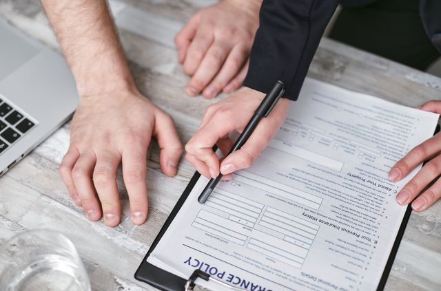  two people signing an insurance policy document